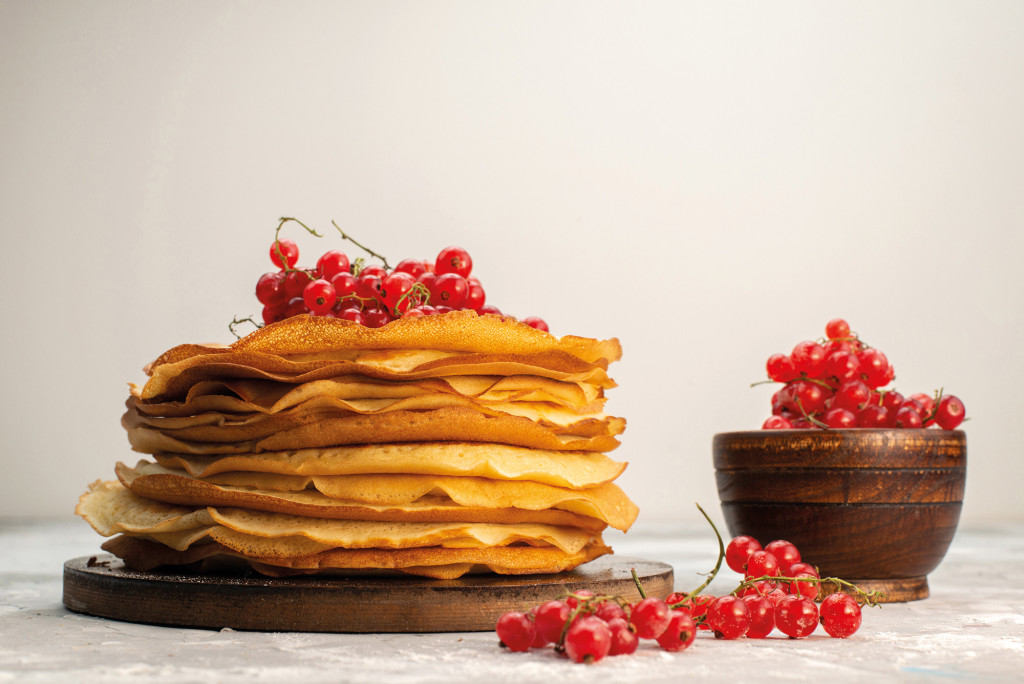 a front view delicious round pancakes yummy and round formed with cranberries on the light background pancake pastry cooking