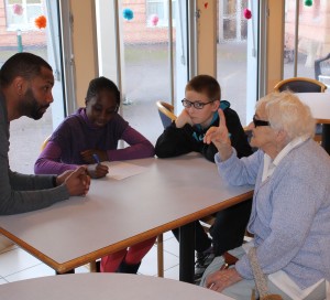 L’Espace Laïque Vernonnais porte le projet « Lieu de mémoire », en partenariat avec les centres sociaux de la ville (Espace Simone-Veil et Pénitents). Des jeunes âgés de 12 à 14 ans ont choisi des lieux de mémoire (monuments, lieux historiques…) du territoire, afin de réaliser des affiches à leur effigie. Ils sont partis à la rencontre des anciens (ci-dessus, à l'EHPAD Auguste-Ridou) qui ont pris plaisir à relater leurs souvenirs autour des sites sélectionnés. Ce projet a donc permis des rencontres intergénérationnelles, avec l'organisation d'un goûter avec les personnes âgées, ainsi que d'une journée pique-nique et visite de la ville. Les jeunes avaient à cœur d’aider les personnes âgées et de partager un moment citoyen avec eux. Un après-midi diffusion de photos et de films d’avant-guerre (proposé par Alexandre Révérend) a permis aux enfants de découvrir leur ville à une période qu’ils n’ont pas connue. Forts du travail de recherche accompli, ils organisent une exposition, qui se déplacera dans différents lieux de la ville durant plusieurs mois. Elle sera visible : - à l'espace Simone-Veil jusqu'au 1er juillet, - dans le hall de la mairie de Vernon du 5 juillet au 1er septembre, - au centre social des Pénitents du 1er septembre au 9 octobre, - à l'EHPAD Auguste-Ridou du 9 au 15 octobre. Elle viendra ensuite compléter « Espace dans ma Ville » à Simone-Veil du 30 octobre au 3 novembre. À la suite de ce circuit, l’exposition devrait circuler au sein des collèges.