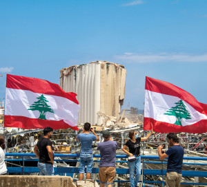 Beirut / Lebanon  - 08 09 2020: Scores of Lebanese wave the Lebanese flag at the scene of Tuesday's massive blast in Beirut which killed at least 150 people and left thousands injured.
