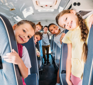 Group,Of,Cute,Schoolchildren,Riding,On,School,Bus,And,Looking