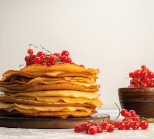 a front view delicious round pancakes yummy and round formed with cranberries on the light background pancake pastry cooking